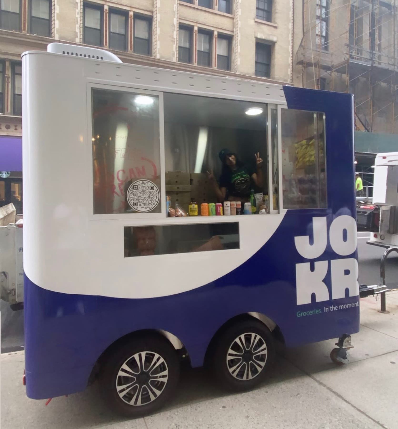A JOKR-wrapped cart with its service window open on a Manhattan street