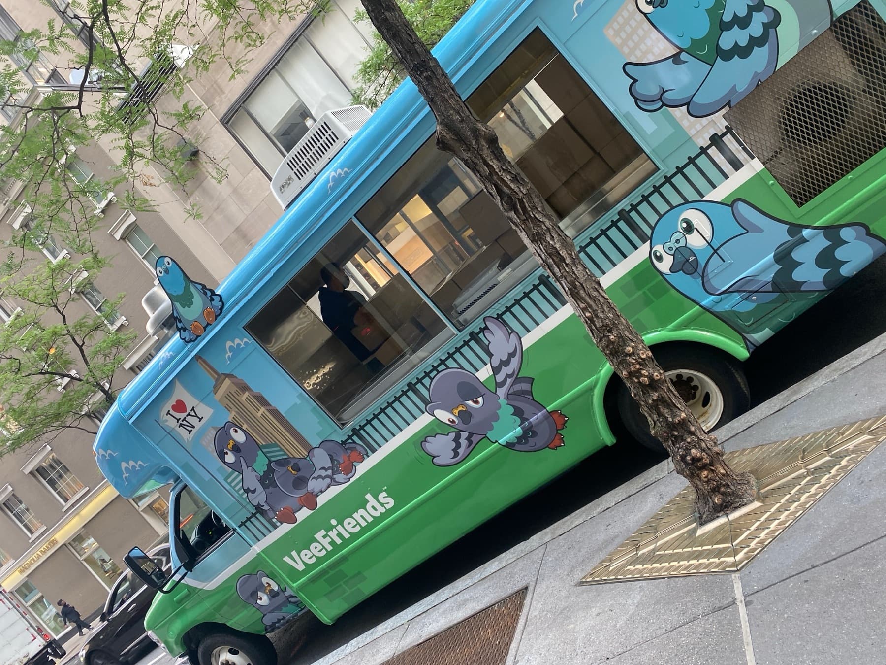 A truck wrapped with VeeFriends pigeon characters on a New York street